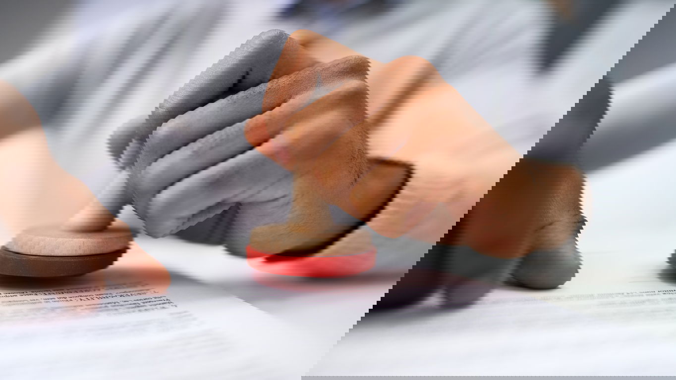 iStock-1189508430.jpg A man stamping a document